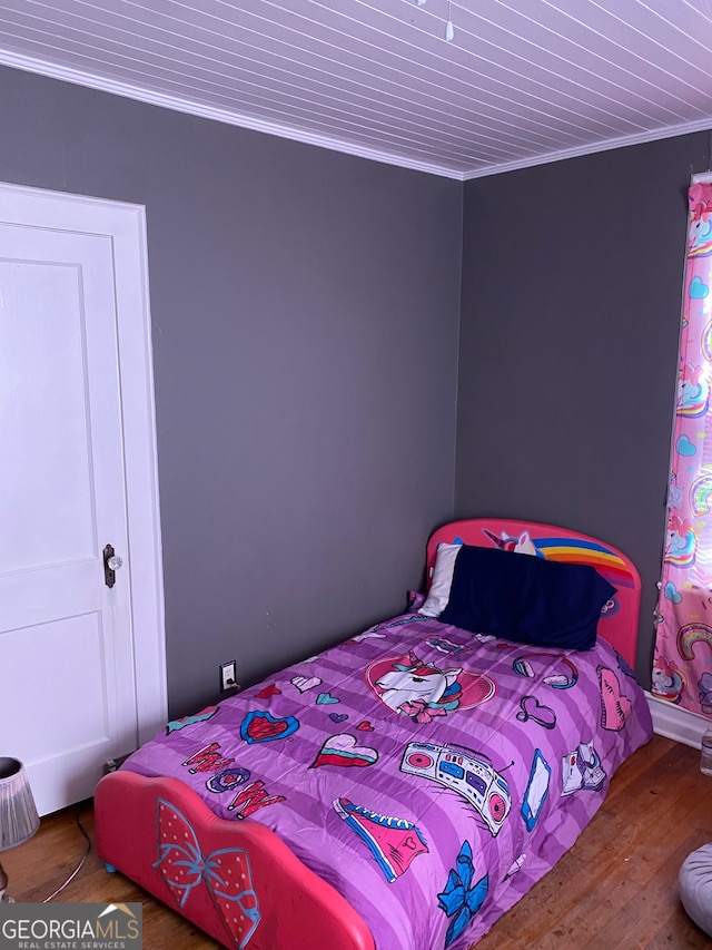 bedroom with crown molding and hardwood / wood-style flooring