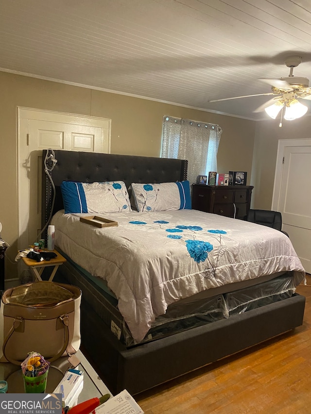 bedroom featuring ceiling fan, crown molding, and light hardwood / wood-style flooring