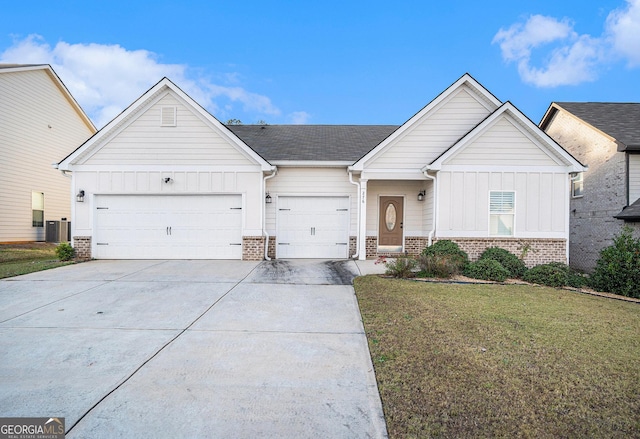 view of front of house with a garage, a front lawn, and central air condition unit