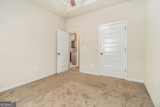 unfurnished bedroom featuring carpet, ceiling fan, and a closet