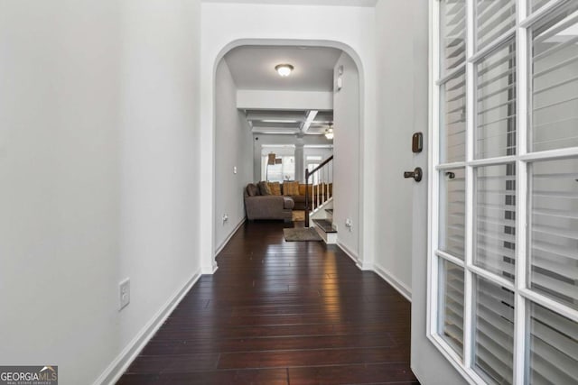 hall with beam ceiling, coffered ceiling, and dark hardwood / wood-style floors