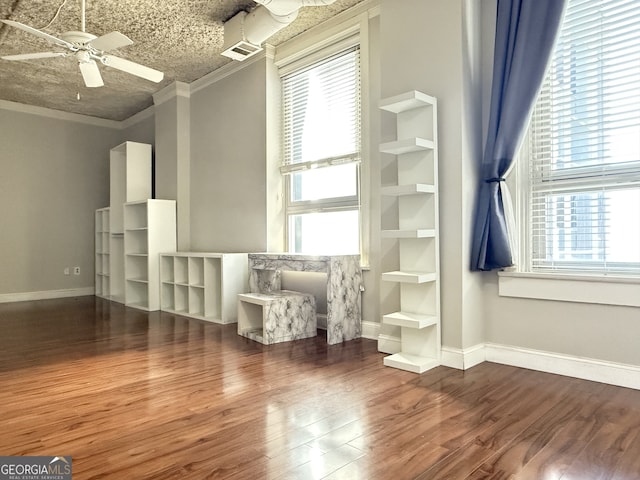 unfurnished room with ornamental molding, a healthy amount of sunlight, ceiling fan, and dark hardwood / wood-style flooring