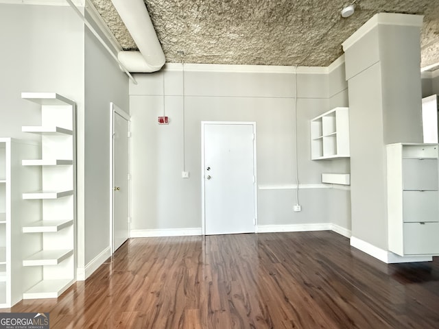 interior space featuring crown molding and dark hardwood / wood-style flooring