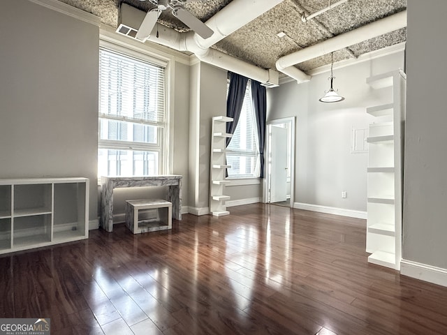 empty room featuring ceiling fan, plenty of natural light, and dark hardwood / wood-style floors