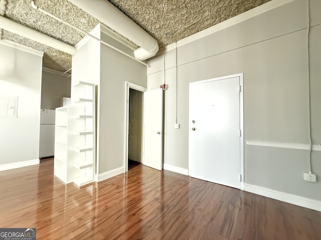 unfurnished room with ornamental molding and hardwood / wood-style flooring