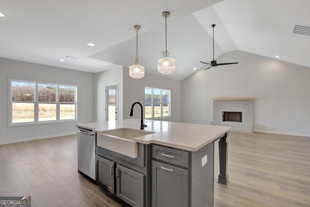 kitchen featuring a center island with sink, vaulted ceiling, a healthy amount of sunlight, and sink