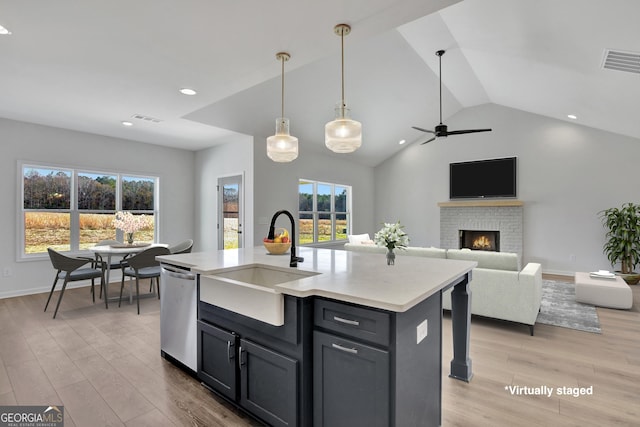 kitchen with a kitchen island with sink, sink, stainless steel dishwasher, and plenty of natural light