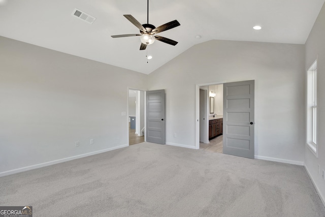 unfurnished bedroom with high vaulted ceiling, ceiling fan, light colored carpet, and connected bathroom