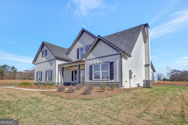 view of front of house with central air condition unit, a front lawn, and a porch