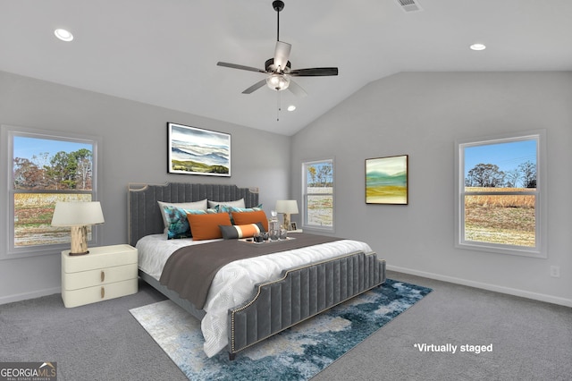 carpeted bedroom featuring vaulted ceiling, multiple windows, and ceiling fan