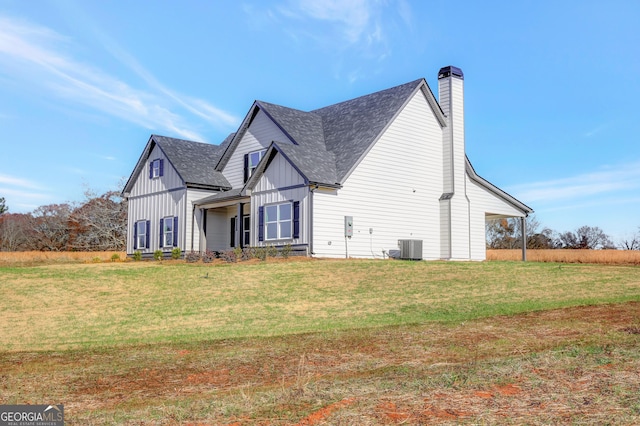 view of side of property featuring central AC and a lawn