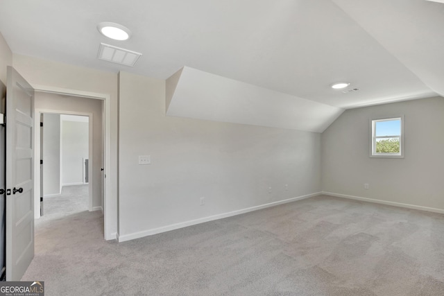 bonus room with light carpet and lofted ceiling