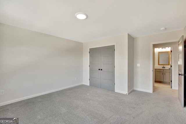 unfurnished bedroom with light colored carpet, a closet, and sink