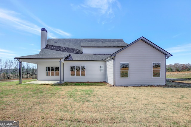 back of property with a patio area and a lawn