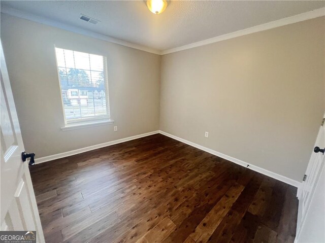 unfurnished room with dark hardwood / wood-style floors and ornamental molding