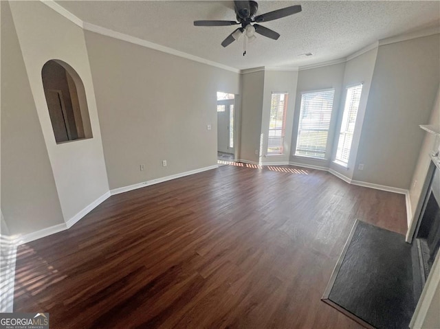 unfurnished living room with dark wood-type flooring, ceiling fan, a textured ceiling, and ornamental molding