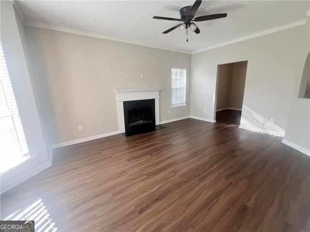 unfurnished living room with ceiling fan, dark hardwood / wood-style flooring, and ornamental molding