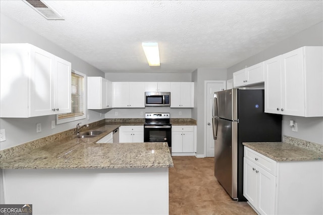 kitchen featuring sink, a textured ceiling, kitchen peninsula, white cabinetry, and stainless steel appliances