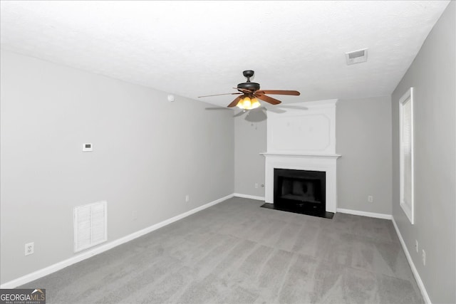 unfurnished living room featuring a textured ceiling, light colored carpet, and ceiling fan