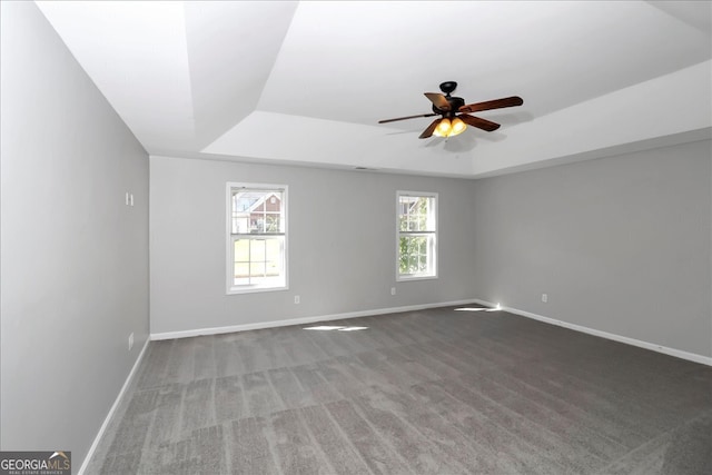 carpeted empty room with a tray ceiling and ceiling fan