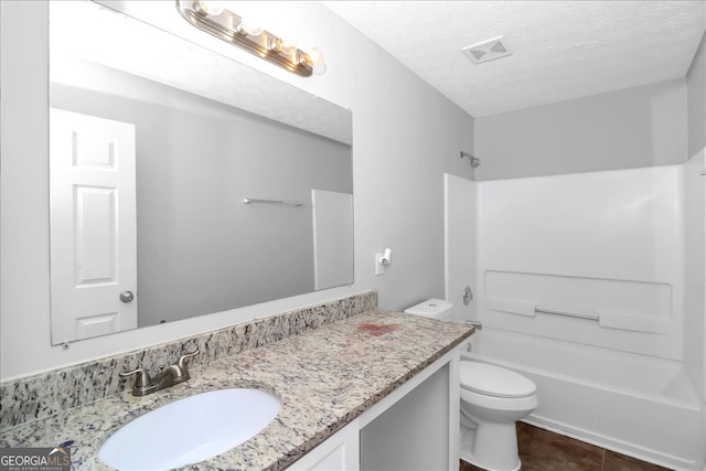 full bathroom with tile patterned floors, toilet, bathing tub / shower combination, vanity, and a textured ceiling