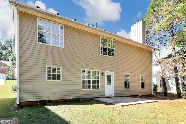 back of house with a yard and a patio