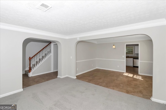 spare room featuring crown molding, carpet floors, and a textured ceiling