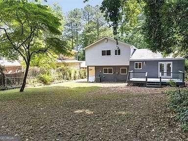 rear view of house featuring a wooden deck