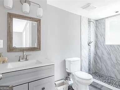 bathroom featuring vanity, toilet, and curtained shower