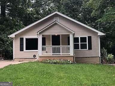 bungalow-style house with a porch and a front lawn