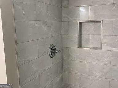 interior details featuring a tile shower