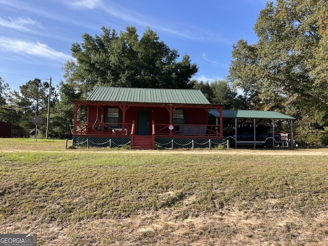 view of front facade with a carport, a porch, and a front lawn