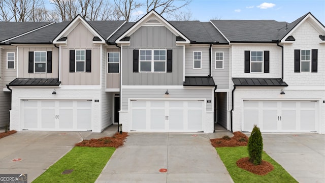 353 Sound Cir, Stockbridge, GA 30281 - multi unit property featuring an attached garage, driveway, a standing seam roof, board and batten siding, and metal roof