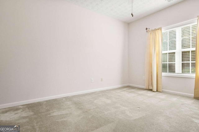 carpeted empty room featuring a textured ceiling