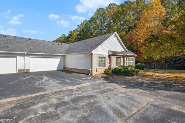 view of front of property with a garage and cooling unit