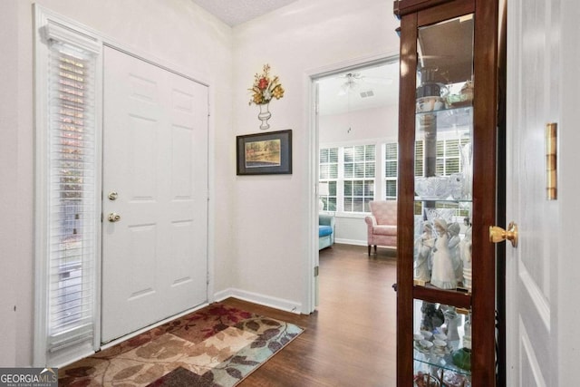 entryway with ceiling fan and dark hardwood / wood-style flooring