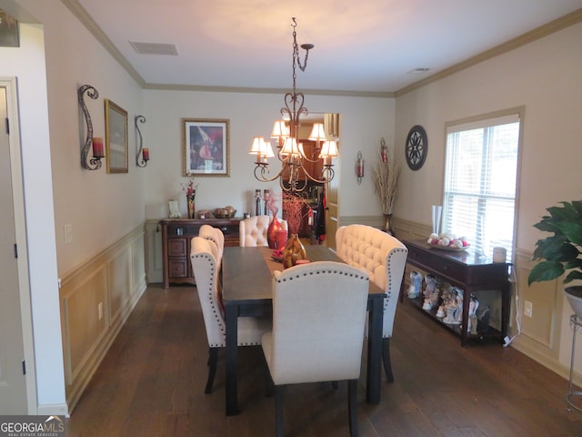 dining area with ornamental molding, dark hardwood / wood-style flooring, and an inviting chandelier