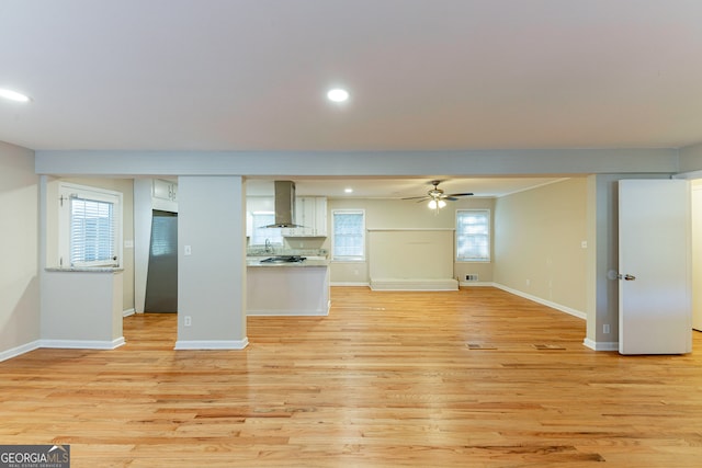 unfurnished living room featuring light hardwood / wood-style floors, a healthy amount of sunlight, and ceiling fan