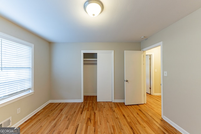 unfurnished bedroom featuring light hardwood / wood-style floors and a closet