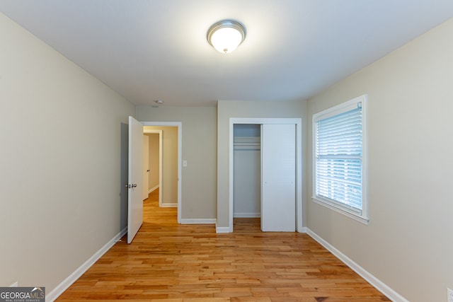 unfurnished bedroom featuring a closet and light wood-type flooring