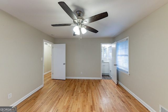 unfurnished bedroom featuring light hardwood / wood-style flooring, ensuite bathroom, and ceiling fan