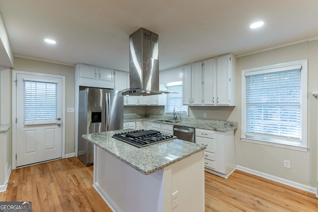 kitchen with white cabinetry, island exhaust hood, light stone counters, and plenty of natural light