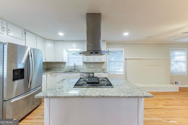 kitchen featuring island exhaust hood, sink, white cabinetry, appliances with stainless steel finishes, and light hardwood / wood-style floors