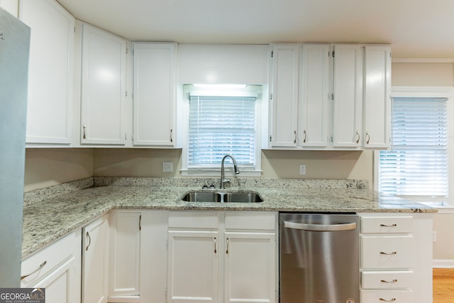 kitchen with white cabinets, light stone countertops, light wood-type flooring, dishwasher, and sink