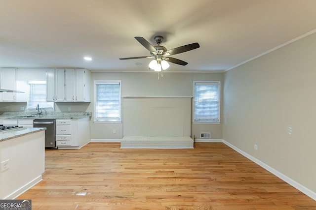 kitchen featuring light stone countertops, white cabinetry, light hardwood / wood-style floors, stainless steel dishwasher, and crown molding