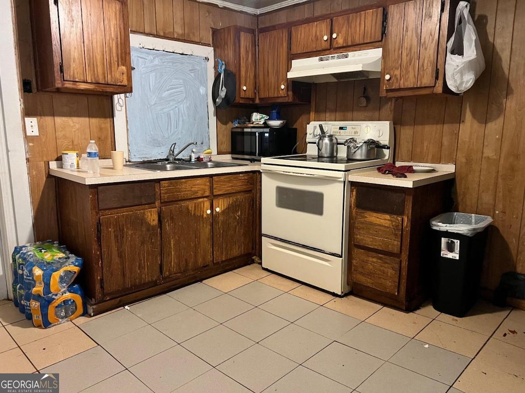 kitchen with sink, electric range, and wooden walls