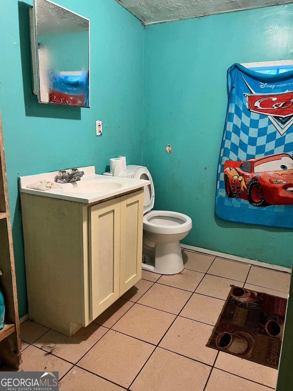 bathroom with vanity, a textured ceiling, toilet, and tile patterned floors