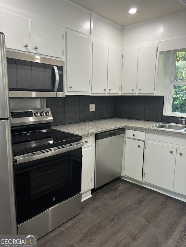 kitchen with white cabinets, stainless steel appliances, decorative backsplash, and sink