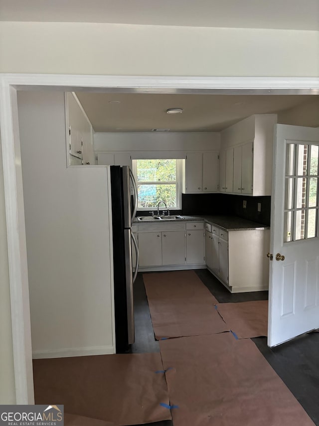 kitchen featuring sink, white cabinets, and decorative backsplash