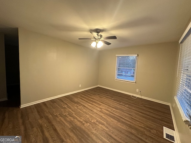 spare room with plenty of natural light, ceiling fan, and dark hardwood / wood-style flooring